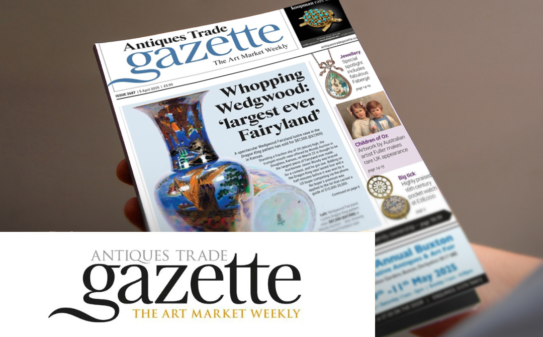A person holding a copy of the Antiques Trade Gazette magazine. The cover features the headline 'Whopping Wedgwood: largest ever Fairyland' with images of colorful Wedgwood pottery. The magazine includes sections on jewelry featuring Fabergé items and 'Children of Oz' artwork. The masthead shows 'Antiques Trade Gazette' in blue text with 'The Art Market Weekly' tagline. At the bottom of the image is a larger version of the Antiques Trade Gazette logo in black and gold text. The image relates to an April 2025 article about Ronati Studio, a cloud-based platform designed to help antiques dealers manage their inventory.