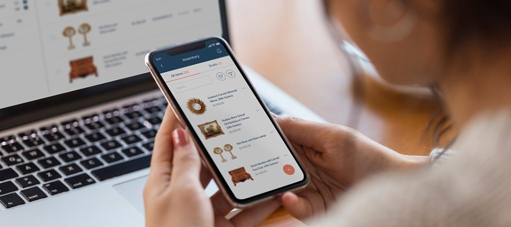 Antique dealer managing their inventory with Ronati Studio's mobile app while simultaneously viewing items on their laptop - showcasing the seamless cross-device functionality that has enabled over 45,000 sessions in less than two months after launch.