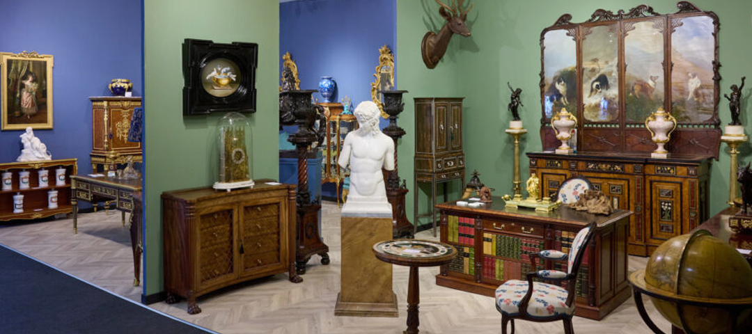 Exhibitor booth at LAPADA Berkeley Square Fair displaying Renaissance and 19th-century furniture, marble sculpture, and decorative arts.