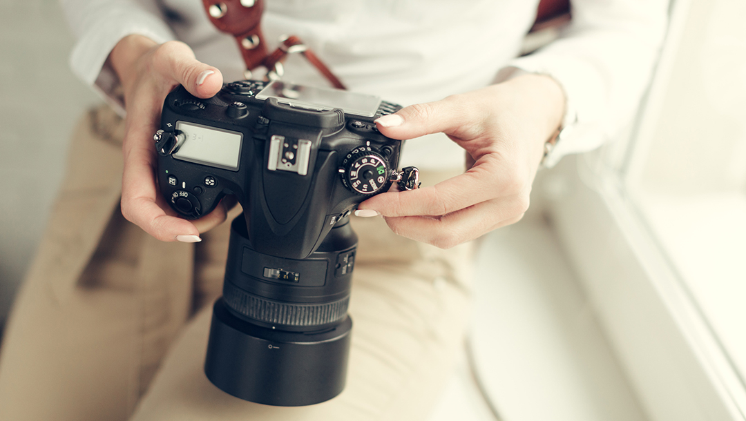 Dealer adjusting camera settings before photographing inventory, highlighting the role of quality images in bringing antiques online.